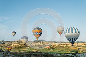 scenic view of colorful hot air balloons flying over valley of
