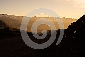 Scenic view of a dirt road winding through rocky mountains during a sunset