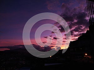 Scenic view of a dramatic purple sunset sky over the town