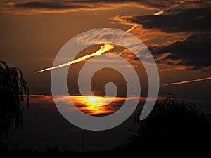 Scenic view of the dramatic sky with dark clouds at sunset