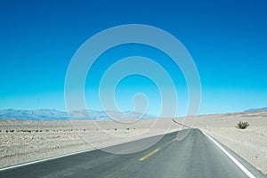 Scenic view of an empty highway against the blue sky