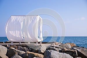 Scenic view empty white beach wooden canopies cabanas with white curtain blowing by wind against sea or ocean san