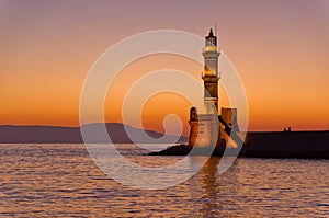 Scenic view of the entrance to Chania harbor with lighthouse at sunset, Crete