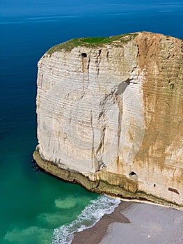 Scenic view of the Etretat coastline in northern France, featuring a blue sea and rocky shores.