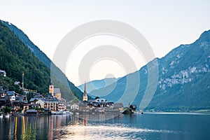 Scenic view of famous Hallstatt lakeside town reflecting in Hallstattersee lake in the Austrian Alps on a sunny day in summer,