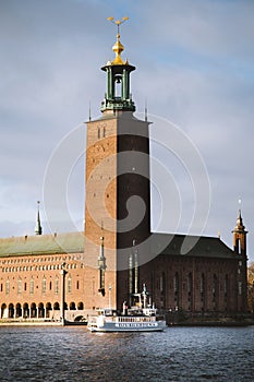 Stockholm city hall with Djurgarden ferry boat at sunset, Sweden, Scandinavia photo