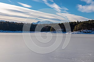Scenic view of frozen alpine lake Forstsee and Karawanks mountains, Techelsberg, Carinthia (Kaernten), Austria, Europe.