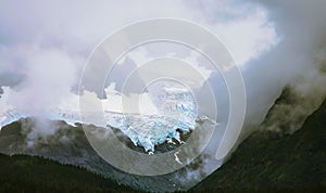 Scenic view of Godwin Glacier with low hills enveloped in fog in Alaska