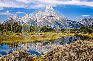 Scenic view of Grand Teton mountains with water reflection