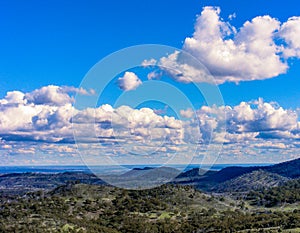 Scenic view with green hills and blue sky with white fluffy clouds. photo
