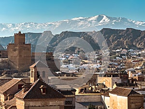 Scenic view of Guadix, Spain with castle, cave houses, and mountains