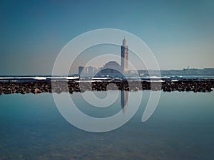Scenic view of Hassan II mosque Reflected on water on a sunny day