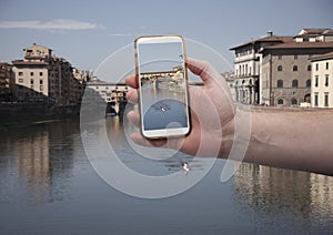 Scenic view of historical center Florence bridge and buildings of old town Hand with a smartphone, on the screen of which the