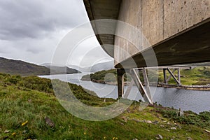Scenic view of the Kylesku Bridge arching over a river in Scotland photo