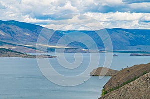 Scenic view of Lake Baikal. View from high cliff. Lake Baikal and mountains with clouds above them