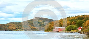 Scenic view of a lake house with uncultivated trees, bushes, shrubs around a bay of water in Norway. Landscape of wild