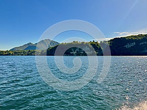 Scenic View of Lake Maggiore with the Hermitage of Santa Caterina del Sasso and Majestic Mountainous Landscape Under a Clear Blue photo