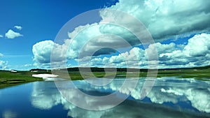 The scenic view of lake with reflecting clouds and sky while driving of the beautiful Yellowstone National Park