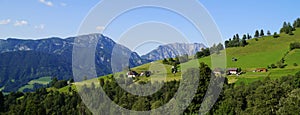 a scenic view of a little village and green meadows in Austrian Alps of Schladming-Dachstein region (Austria)