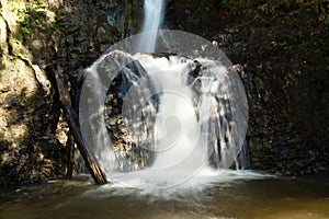 Scenic view on Mae Yen Waterfall with white water on a sunny day.