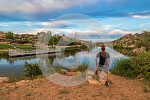 Scenic view of a male seen from behind, standing proudly on a bank of Fain Lake in Prescott Valley