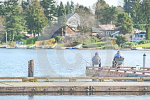 Scenic view of a man fishing on a pier in a big lake in the park.