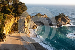 Scenic view of McWay Falls in Big Sur, California with rocks near the coast