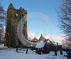 a scenic view of the medieval ruined church in the village of heptonstall west yorkshire covered in snow with surrounding graves