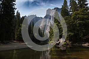 Scenic view of the merced river in the Yosemite valley, with the rocky mountains reflected on the water, in California