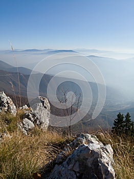 Scenic view from Mount Vlasic, a valley filled with fog and peaks above the fog in autumn during a sunny day