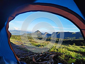 Scenic view of a mountain range covered with mist in morning thorough a camping tent