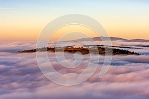 Scenic view of mountains hidden in a sea of clouds at sunset. Kremnica Mountains, Slovakia.