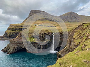 Scenic view of the Mulafossur Waterfall in the Faroe Islands on a cloudy day