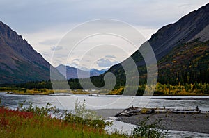 Scenic view of The Nenana river surrounded by beautiful mountains in Alaska during an autumn day