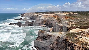 Scenic view of ocean waves crashing on high cliffs. Western coast of Portugal