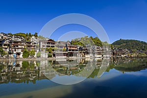 Scenic view of the old houses reflected in water of the Tuojiang River Tuo Jiang River in Phoenix Ancient Town