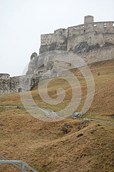 Scenic view of old stone european castle with grey fog on background