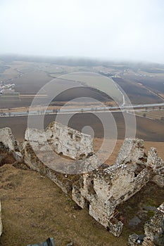 Scénický pohled na starý kamenný evropský hrad s šedou mlhou na pozadí