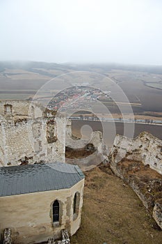 Scénický pohled na starý kamenný evropský hrad s šedou mlhou na pozadí