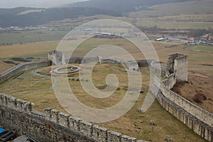 Scénický pohled na starý kamenný evropský hrad s šedou mlhou na pozadí