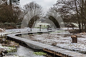 Scenic view over a wooden path through the Brussels wetlands, covered with snow in Molenbeek