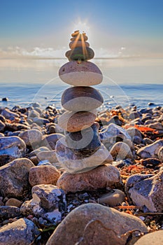 Scenic view of a pebble tower on a rocky beach at sunset