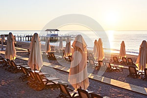 Scenic view of private sandy beach with sun beds and parasokamy the sea and mountains. Resort.