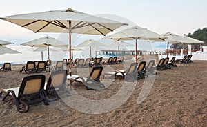 Scenic view of private sandy beach with sun beds from the sea and the mountains. Amara Dols Vita Luxury Hotel. Resort. Tekirova Ke