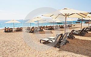 Scenic view of private sandy beach with sun beds from the sea and the mountains. Amara Dols Vita Luxury Hotel. Resort