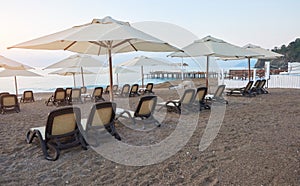 Scenic view of private sandy beach with sun beds from the sea and the mountains. Amara Dols Vita Luxury Hotel. Resort