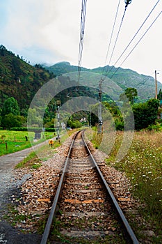 Scenic view of railroad tracks winding through an expansive countryside landscape in Asturias, Spain