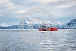 Scenic view of a red boat in a Norwegian fjord in winter