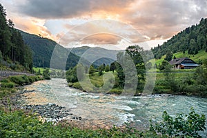 Scenic view of a rippling river in the Alps at sunset