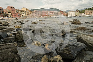 Scenic view of the rocks in bay of the Silence in Sestri Levante, Liguria, Italy across the colorful houses, mountains and coastli photo